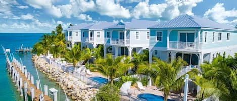 A waterfront property with multiple buildings, a dock, and a swimming pool.