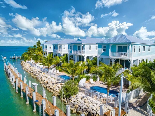 A waterfront property with multiple buildings, a dock, and a swimming pool. - Sunset Colors on Vaca Cut! Private Pool, Boat Slip, Kayak, Paddleboards & Games! (Marathon)