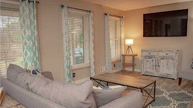 A living room with a sofa, a coffee table, a lamp, and a TV on the wall. - cozy heaven (Sparks)