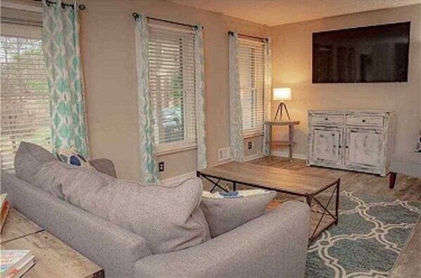 Relax in this cozy living space with a sofa, coffee table, and TV for your entertainment.
