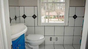 A bathroom with a toilet, a sink, and a window. - cozy heaven (Sparks)