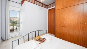 Un dormitorio con cama, armario, ventana con vistas y lámpara en el techo.