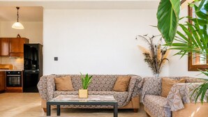 Ein Wohnzimmer mit einer Couch, einem Couchtisch und einer Topfpflanze.