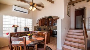 A spacious kitchen with wooden cabinets, a dining area with a round table, and a staircase leading to another level. - OCEANFRONT - Stunning, unobstructed views! (San Carlos Nuevo Guaymas)