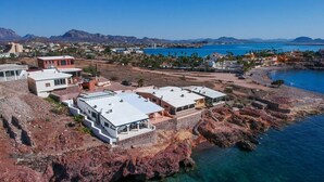 A coastal property with multiple buildings, including a large white structure with a flat roof and a smaller red building. - OCEANFRONT - Stunning, unobstructed views! (San Carlos Nuevo Guaymas)