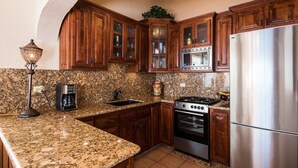 A kitchen with granite countertops, wooden cabinets, a stainless steel refrigerator, a built-in oven, and a coffee maker. - OCEANFRONT - Stunning, unobstructed views! (San Carlos Nuevo Guaymas)
