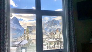 A window with a view of a mountain and buildings.