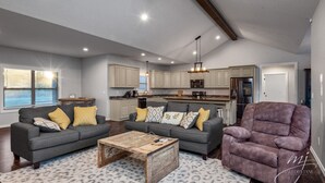 A spacious living area with a gray sofa set, a wooden coffee table, and a purple recliner. - Norfork Lake: Family Retreat  (Calico Rock)
