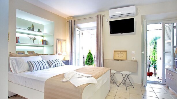 Una habitación de hotel con cama, escritorio, televisión y vistas al exterior.