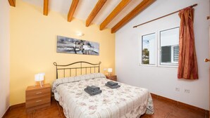 A bedroom with a bed, bedside tables, a painting, a window, and a curtain. - Villa La Luna - Three Bedroom Villa, Sleeps 6 (Ciutadella de Menorca)