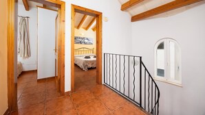 A hallway with a bed, a window, and a staircase. - Villa La Luna - Three Bedroom Villa, Sleeps 6 (Ciutadella de Menorca)