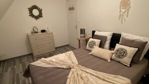 A bedroom with a bed, dresser, and a wall-mounted mirror.