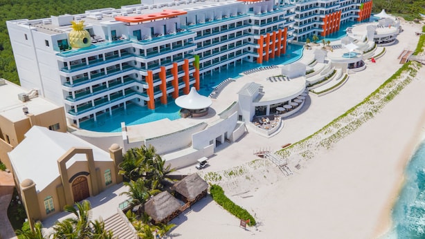 Un gran resort con varias piscinas, una zona de playa y vistas al océano.