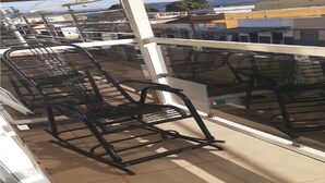 A balcony with metal chairs and a view of the cityscape. - House Located in the Center of Guape Mg (Guapé)