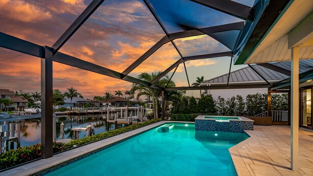 A swimming pool with a view of the marina and sunset. - Marco Island Waterfront Escape | Heated Pool + Hot Tub | Private Dock + Fire Pit (Marco Island)