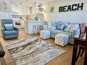 Relax in a nautical-themed living room with a sofa, matching ottoman, and blue armchair.