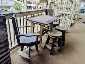 Enjoy a peaceful moment on this balcony with a table and chairs, taking in the view of the surrounding area.