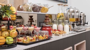 Un buffet de petit-déjeuner proposant une variété de fruits, de céréales et de boissons.