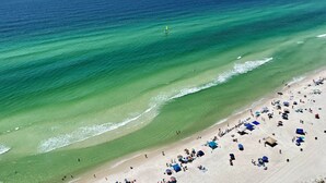 Une plage aux eaux turquoise et limpides, bordée d’un rivage sablonneux.