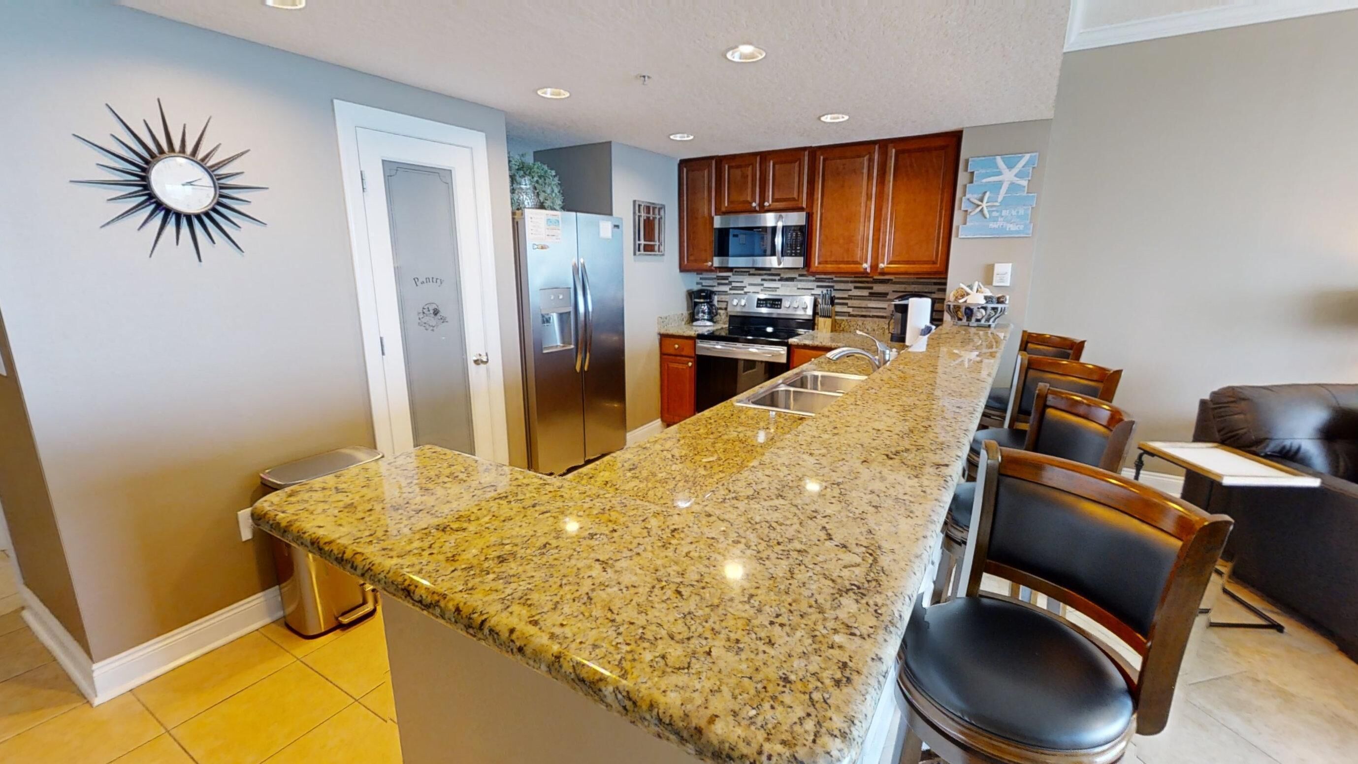 A modern kitchen with granite countertops, stainless steel appliances, and wooden cabinets.