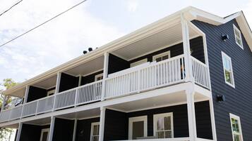 A two-story house with a front porch and a balcony on the upper floor.