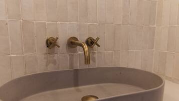 A bathroom with a rectangular sink, a single faucet, and a wall-mounted towel rack.