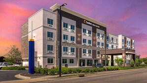 A modern Comfort Inn & Suites building with a stone facade, multiple windows, and a parking lot. - Comfort Inn & Suites Clarksville - Louisville North (Clarksville)
