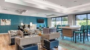 A modern living room with a sofa set, a coffee table, and a TV mounted on the wall. - Comfort Inn & Suites Clarksville - Louisville North (Clarksville)