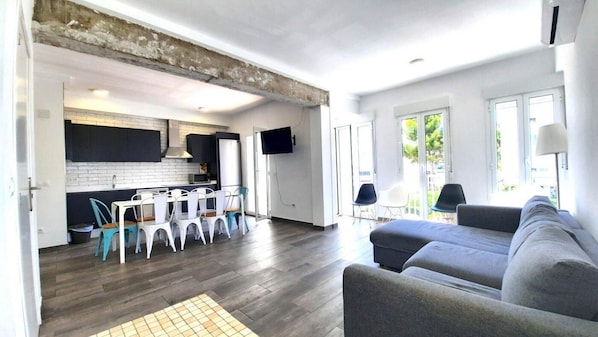 A modern living space with a kitchen, dining area, and seating area.