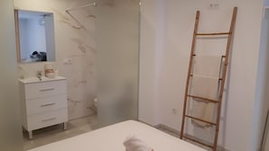 A bedroom with a white bed, a wooden ladder, a bathroom with a marble wall, and a white dresser. - Loft 20 meters from the sea D13 (Gandia)