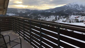 A balcony with a view of snow-covered mountains and a village. - Splendid 4+2 attic with panoramic terrace overlooking the mountains (301) (Lavarone)