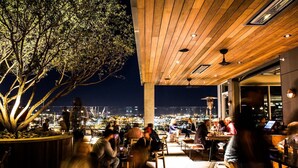 Un área de estar al aire libre con vistas a la ciudad iluminada de noche.