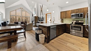 Une cuisine moderne avec des meubles en bois, des appareils en acier inoxydable et un grand îlot central.