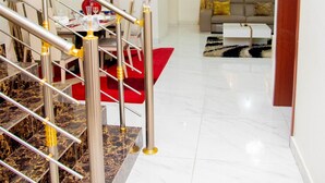 Un salon moderne avec un escalier, un coin repas et un ensemble de canapés.