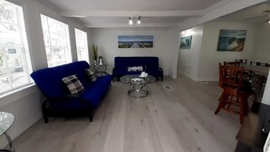 A living room with a blue sofa, a round coffee table, and a dining area with wooden chairs. - 3 MIN FROM PRIVATE BEACH & BOAT RAMP (Key Largo)