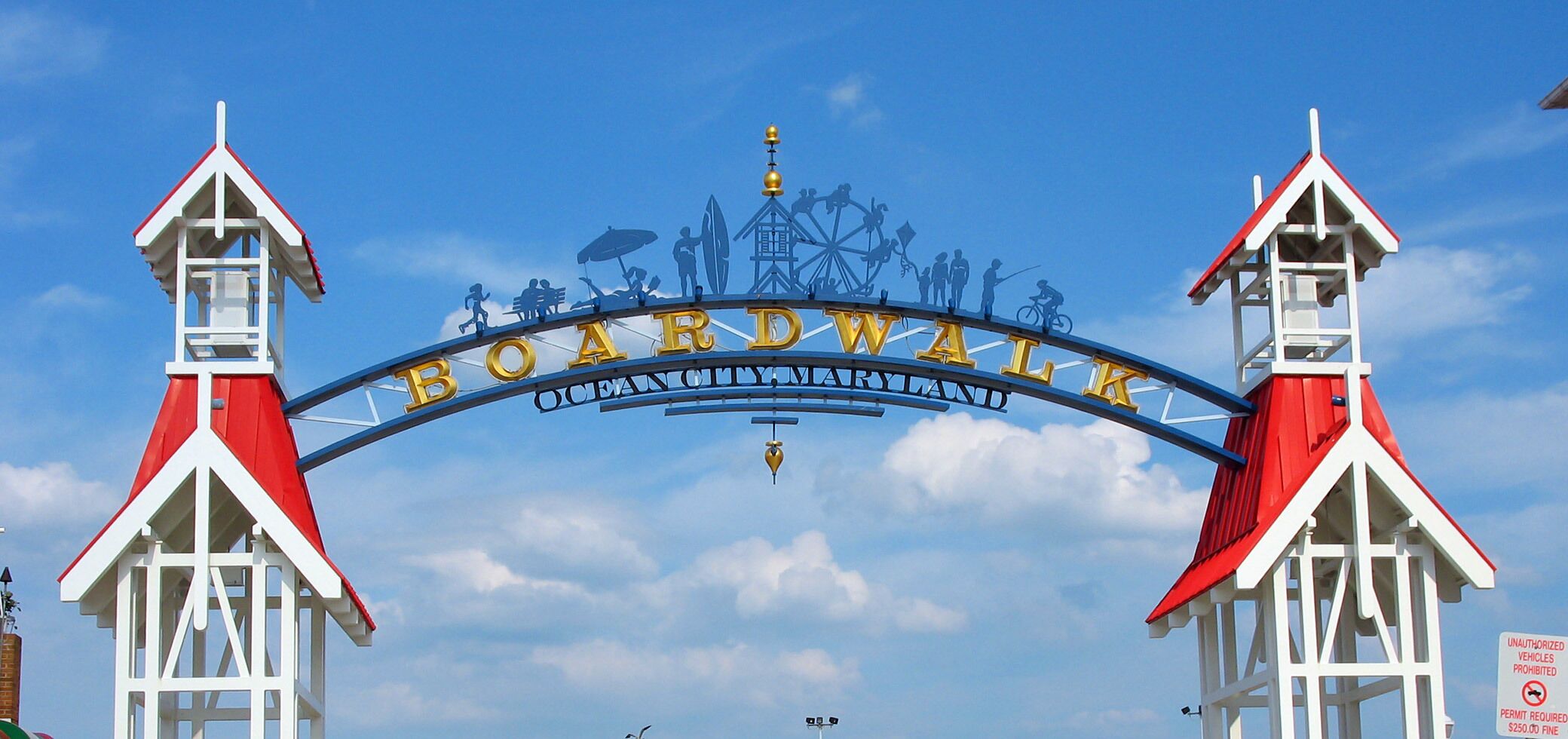 A sign with 'Boardwalk Ocean City Maryland' and silhouettes of beach activities.