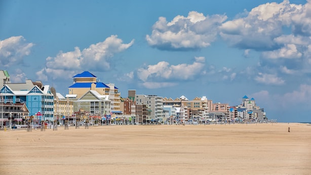 Un hotel sulla costa con diversi edifici, una spiaggia sabbiosa e un cielo sereno.