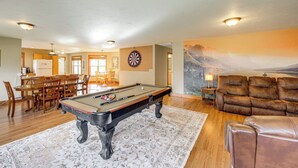 A pool table in a living room with a dining area and a couch. - Columbia Falls Private Retreat: Pool Table & Deck! (Columbia Falls)