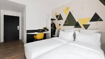 Una habitació d'hotel moderna amb un llit gran, un escriptori i una cadira.