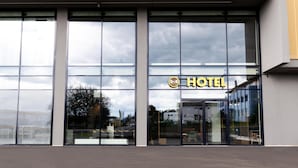 A modern hotel entrance with large glass windows and a clear view of the interior. - B&B Hotel Oftringen (Oftringen)
