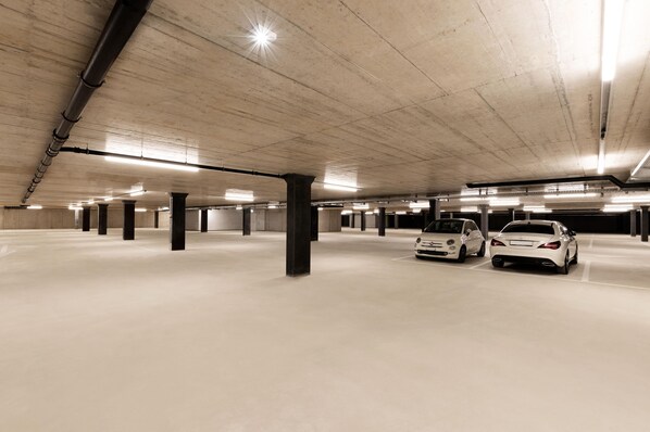 A spacious underground parking garage with concrete pillars and a clean, well-lit environment. - B&B Hotel Oftringen (Oftringen)