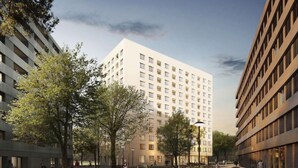 Un edificio moderno con un patio central, rodeado de árboles y un sendero.