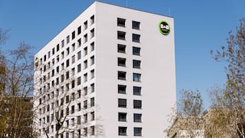 Un grand immeuble blanc, sur lequel on peut voir le logo de la chaîne B&B Hotels.