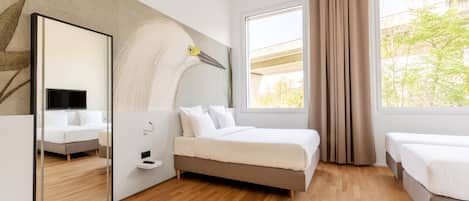 Una habitación de hotel moderna con una cama grande, una cama más pequeña, un espejo y una ventana con cortinas.