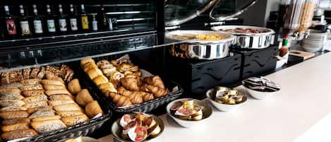 Un bufé con panes, pasteles y productos para desayuno.
