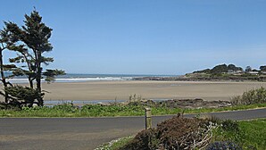 A coastal road with a beach view, a wooden fence, and a clear sky. - Sea it All - Ocean View Yachats (Yachats)