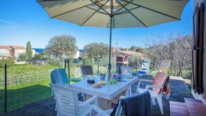 An outdoor patio with a table, chairs, and a large umbrella.