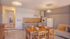 A compact kitchen with a dining table, chairs, and a sofa. - Domaine Bollaccia - Casa Bodri (Monticello)