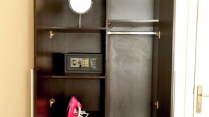 Ein dunkler Holzschrank mit Spiegel, einem Radio und einer roten Handtasche.