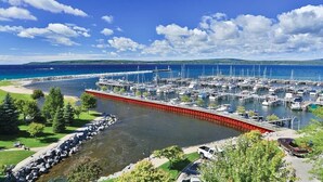 Un port de plaisance avec des bateaux amarrés, une barrière rouge et un ciel d’un bleu limpide.